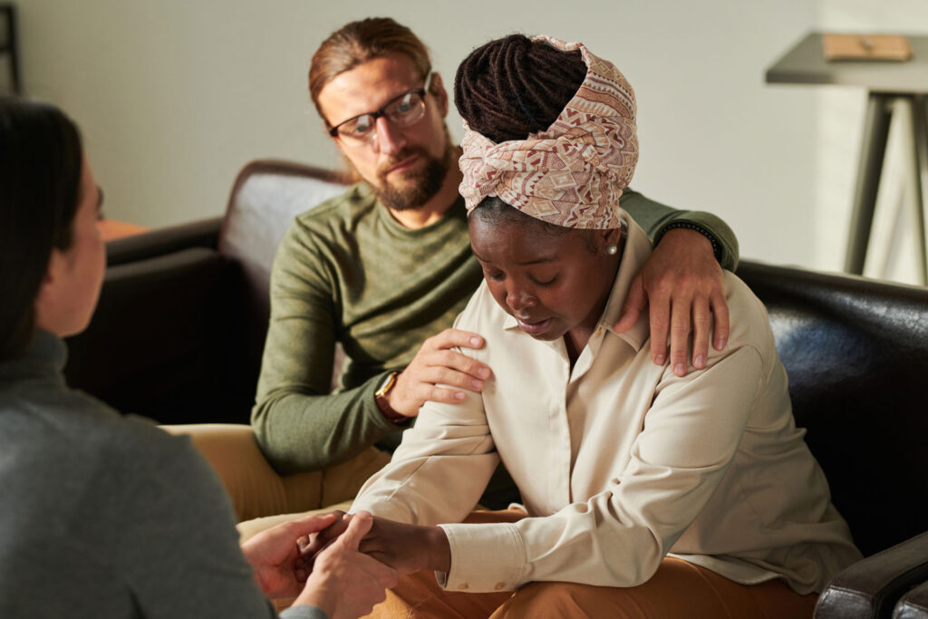 Couple with grief in a psychotherapy with a therapist.