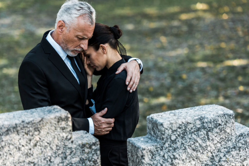 Senior man hugging a woman in grief.