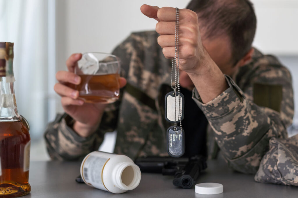 A soldier with PTSD and addiction holding dog tags.