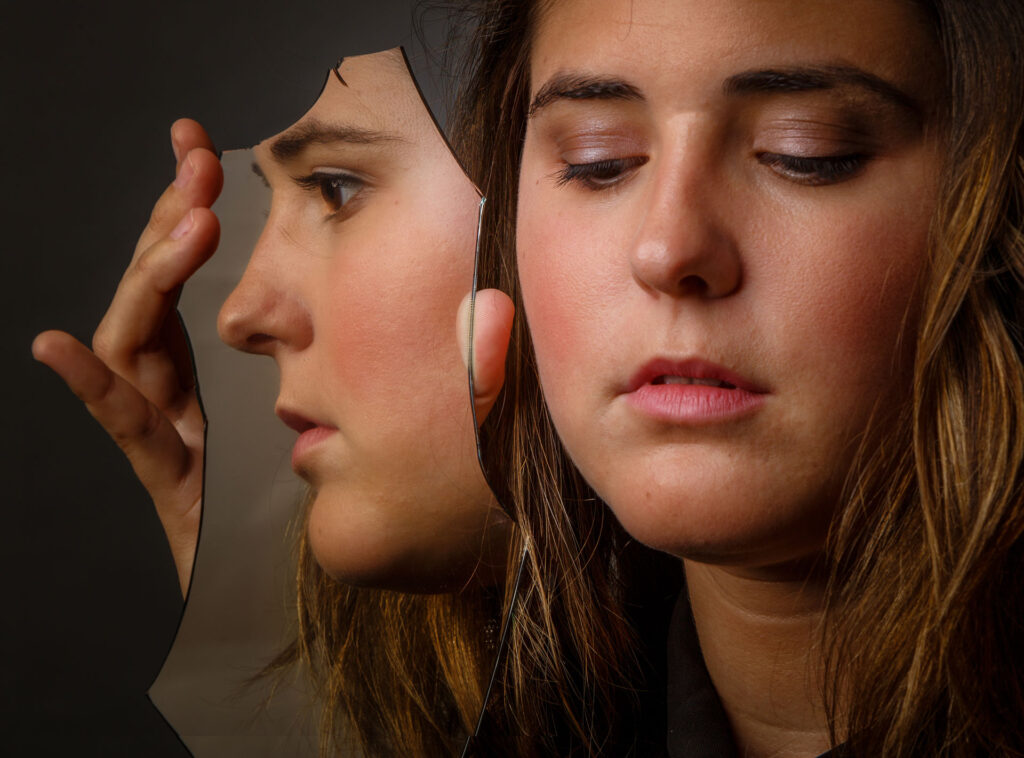 Young woman with reflection in mirror.