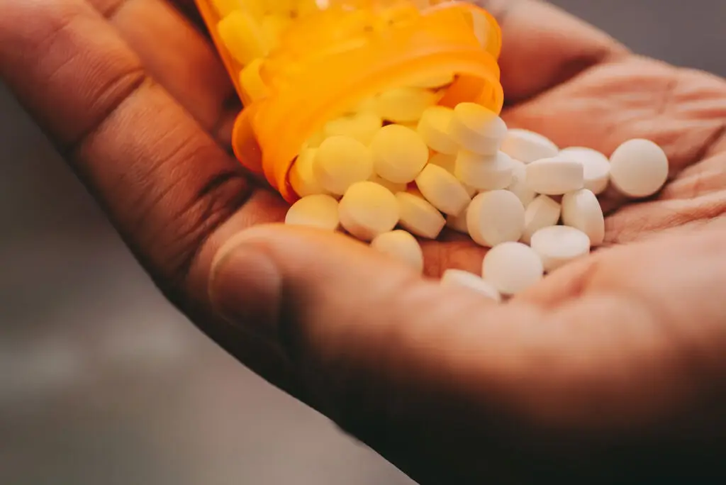 A person pouring medicine in his hands.