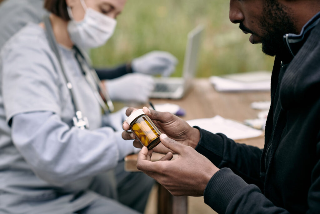 Young sick man, holding prescription drugs.