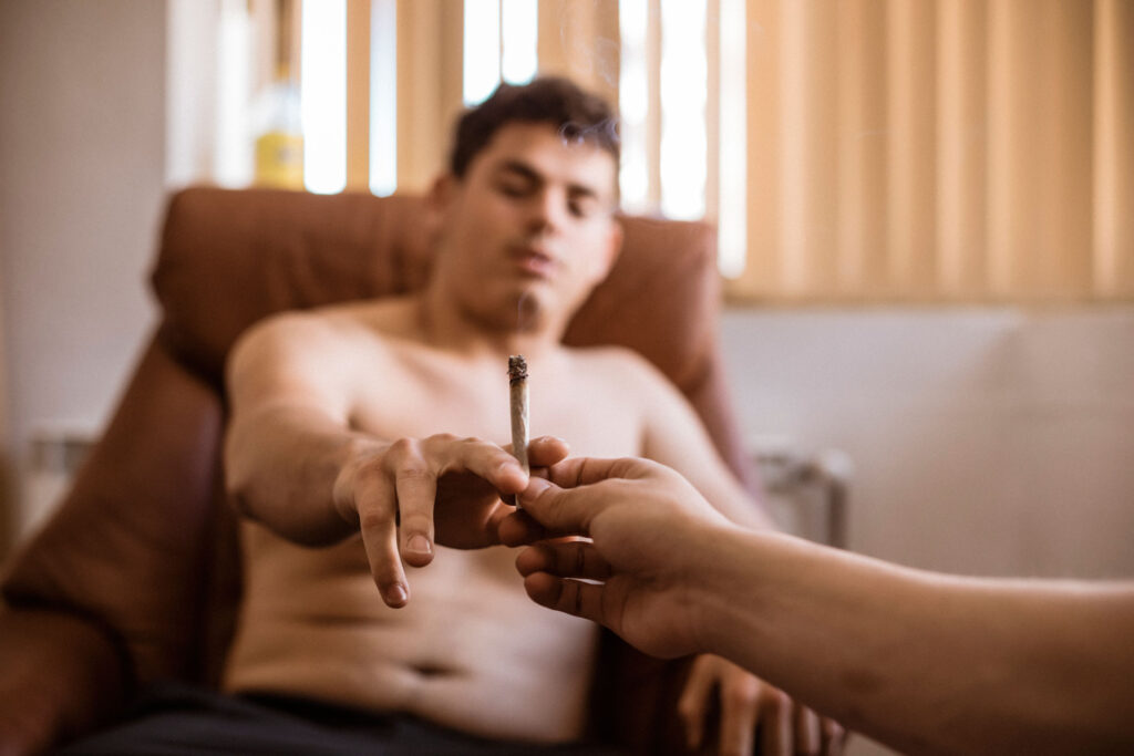 Two men sharing a joint.