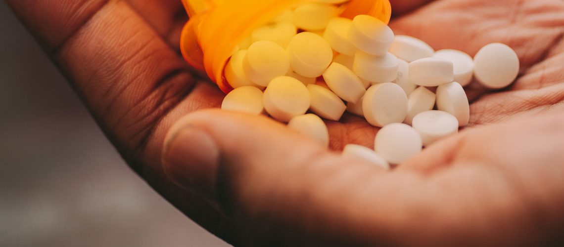 A person pouring medicine in his hands.