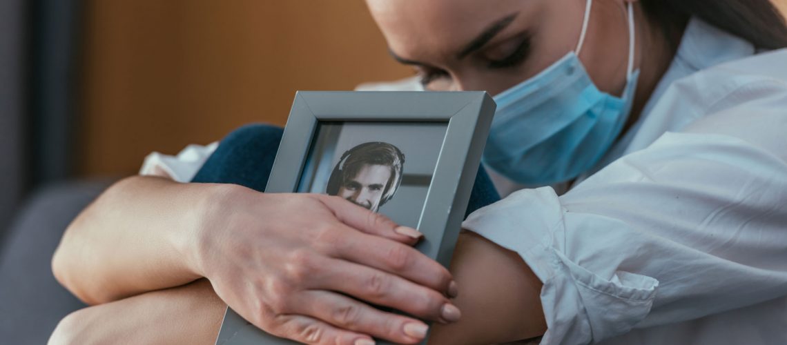 Grieving woman holding a photo of a man.